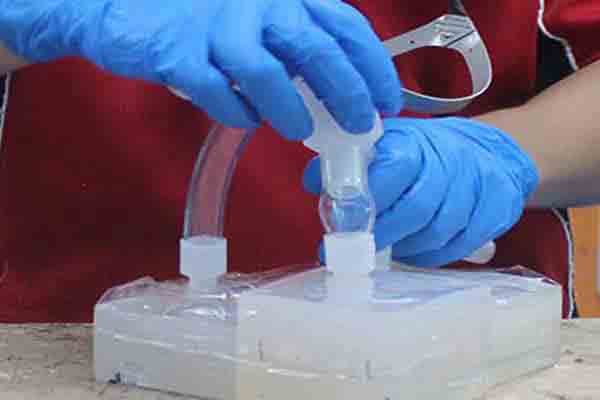 Filling tubes being added to a silicone vacuum casting mold at Michigan CNC Machining Parts, Inc.